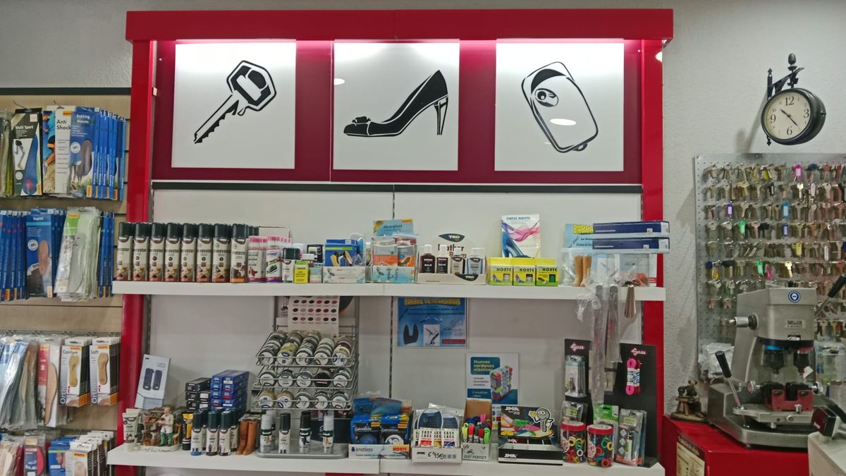 Estantería con productos de cuidado del calzado y máquina de duplicar llaves